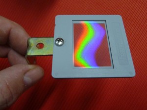 A diffraction grating mounted on a photographic slide frame.
